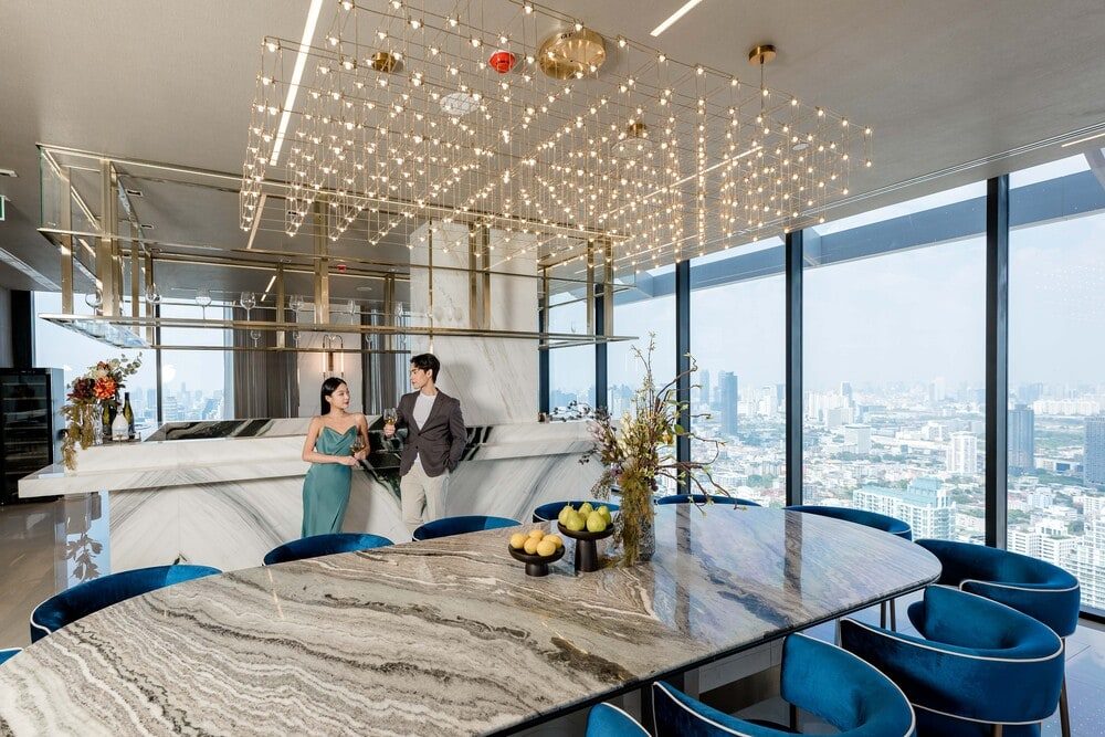 Park Origin Thonglor — dining lounge with a stone table and skyline views