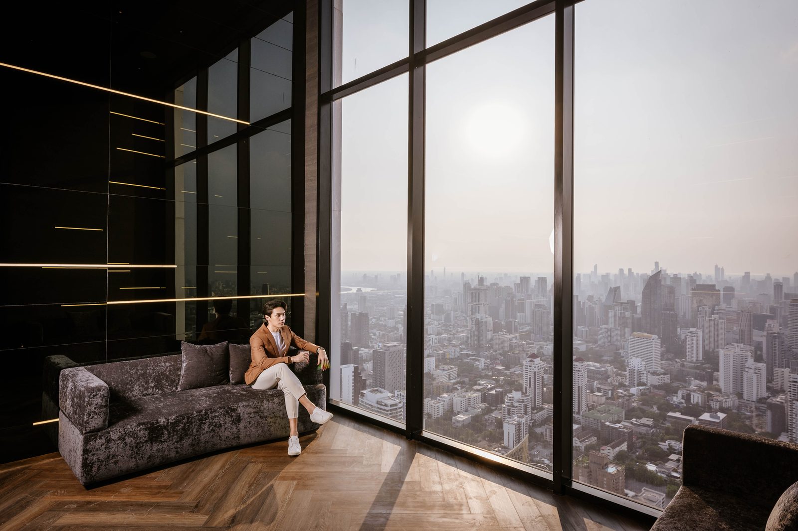 Park Origin Thonglor — sofa by floor-to-ceiling windows over Bangkok